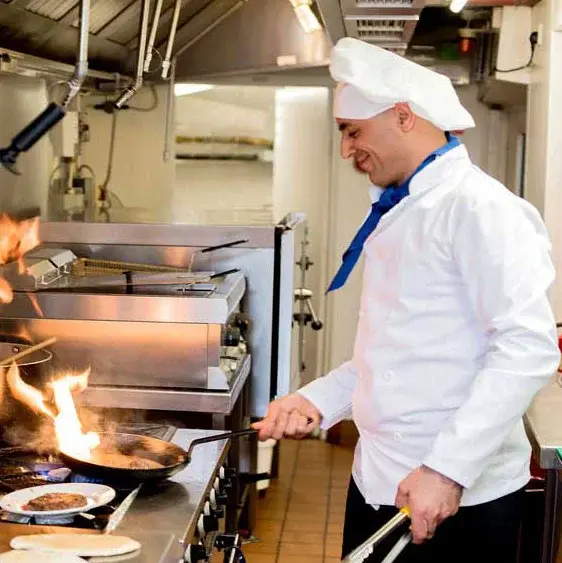 Belmont Gardens Chef Created Meals, chef frying a dish.