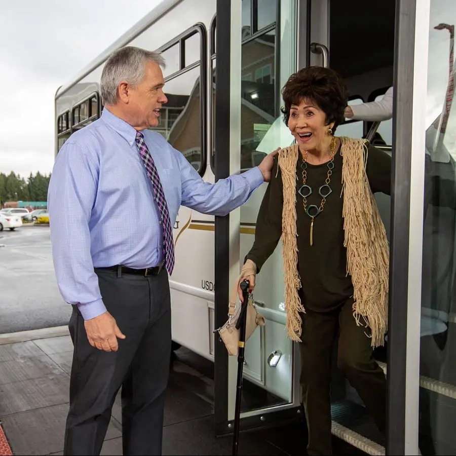 Belmont Gardens man helping lady off bus